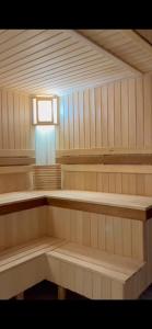 una sauna con bancos de madera y una luz en ella en Зона отдыха в горах en Birgulyuk