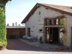 a house with a table and chairs in front of it at La Grange in Coutouvre