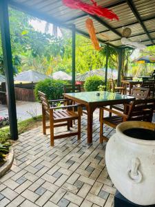 eine Terrasse mit einem Tisch, Stühlen und einer Vase in der Unterkunft Sadamadala Guest House Kandy in Kandy