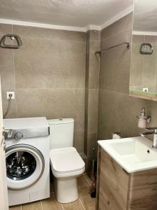 een badkamer met een wasmachine en een wastafel bij KOI Apartment Toumba SKG in Thessaloniki