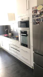 a kitchen with white cabinets and a stainless steel refrigerator at Grand appartement a 5 minutes du stade vélodrome, parking in Marseille