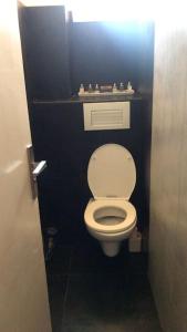 - une salle de bains avec des toilettes blanches dans une cabine noire dans l'établissement Grand appartement a 5 minutes du stade vélodrome, parking, à Marseille