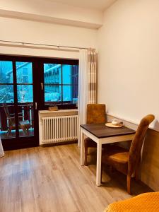 comedor con mesa, sillas y ventana en Wunderschönes Apartment mit Bademantelgang zur Wohlfühltherme, en Bad Griesbach