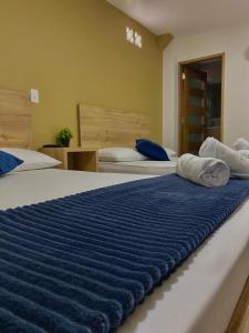 een slaapkamer met 2 bedden met blauwe en witte lakens bij HOTEL GRAN PARAISO in Giraldo
