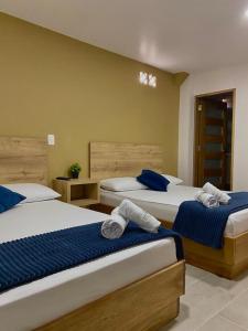 een slaapkamer met 2 bedden met blauwe en witte lakens bij HOTEL GRAN PARAISO in Giraldo