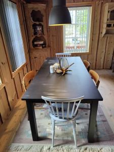 een eettafel met een stoel en een lamp bij Tronstadbu- Traditional cabin in Hellesylt