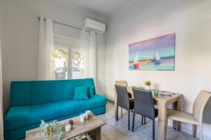 ein Wohnzimmer mit einem blauen Sofa und einem Tisch in der Unterkunft Lemon Tree House in Iraklio