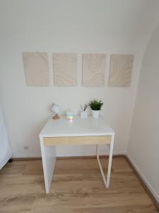 una scrivania bianca con due piante su un muro bianco di Proche du Mont Saint Michel Appartement de vacances a Roz-sur-Couesnon