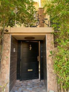 a black front door of a house with a brick walkway at Villa Al Nour avec piscine in Marrakesh
