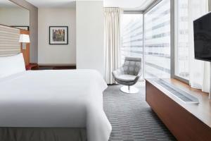 Habitación de hotel con cama, silla y ventana en Club Quarters Hotel Grand Central, New York, en Nueva York