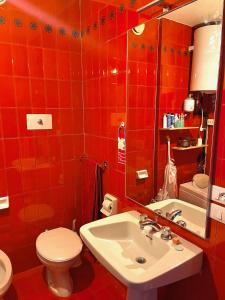 baño de azulejos rojos con aseo y lavamanos en Appartamento per Famiglie, 6 posti, in centro ad Asiago, en Asiago