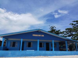 un bâtiment bleu avec un panneau sur lequel figure un panneau dans l'établissement Pousada Costazul, à Superagui