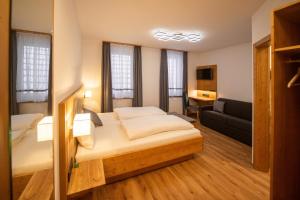 una camera d'albergo con letto e divano di Gasthaus Rotes Ross a Eckental