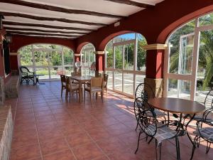 a dining room with tables and chairs and windows at HACIENDA LA HUERTEZUELA y CASA DEL LAGO in Villafranca de Córdoba