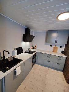 een keuken met witte werkbladen en een wastafel bij Tronstadbu- Traditional cabin in Hellesylt