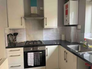 a kitchen with a stove and a sink at Stylish 2 bedroom house Edgware, Barnet in Hendon