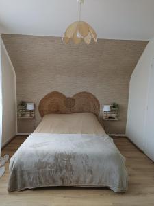 una camera con un grande letto con testiera in legno di Proche du Mont Saint Michel Appartement de vacances a Roz-sur-Couesnon