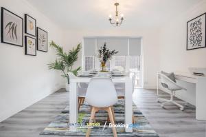 a white dining room with a white table and chair at 5 Bed House By Sentinel Living Short Lets & Serviced Accommodation Windsor Ascot Maidenhead With Free WiFi & Garden in White Waltham