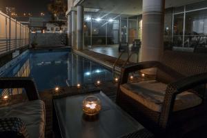 uma piscina com mesa e cadeiras e uma vela em NH Antofagasta em Antofagasta