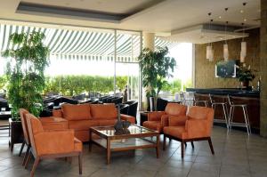a lobby with orange chairs and a bar at NH Antofagasta in Antofagasta