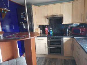 a kitchen with white cabinets and a stove top oven at Bastolino in Newtongrange