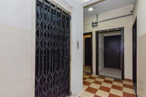 um corredor com uma porta de metal negro num edifício em Collection O Krushna Rooms em Vagholi