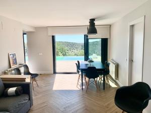 een woonkamer met een blauwe tafel en stoelen bij CHALET NUEVO EN LA MONTAÑA, CON CHIMENEA in Torremocha de Jarama