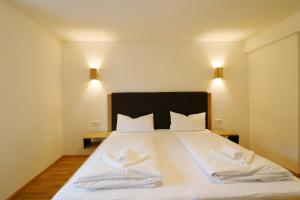una camera da letto con un grande letto bianco con due cuscini di Tannenhof Fischbach - Fewo 1 "Felchen" - Schluchsee, 2 Schlafzimmer a Schluchsee