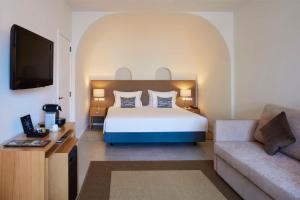 a hotel room with a bed and a couch at Tivoli Lagos in Lagos