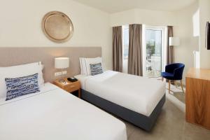 a hotel room with two beds and a window at Tivoli Lagos in Lagos