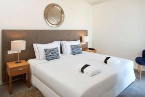 a bedroom with a large white bed and a mirror at Tivoli Lagos in Lagos