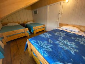 Habitación con 2 camas y 2 mesas. en Hospedaje Nehuen Karu, en Puerto Varas