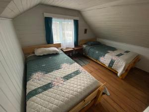 1 dormitorio con 2 camas en una habitación pequeña en Hospedaje Nehuen Karu, en Puerto Varas