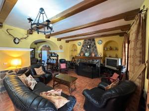 a living room with leather furniture and a fireplace at HACIENDA LA HUERTEZUELA y CASA DEL LAGO in Villafranca de Córdoba