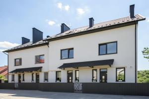 Bild eines weißen Gebäudes mit schwarzen Fenstern in der Unterkunft Таун Terrasa 2floors in Czernowitz