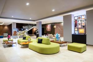 a lobby with green couches and tables and a lobby at Novotel Lima San Isidro in Lima