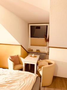 - une chambre avec un lit, une table et une chaise dans l'établissement Appartement mit Bademantelgang zur Wohlfühltherme, à Bad Griesbach im Rottal