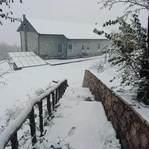 pokryty śniegiem dziedziniec z ogrodzeniem i domem w obiekcie Te Mulliri 