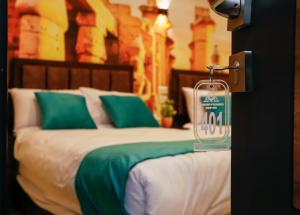 um quarto com uma cama com almofadas verdes e brancas em Diamond Pyramids View Inn no Cairo