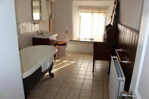 Risley Hall Hotel في Risley: حمام مع حوض ومغسلة ونافذة
