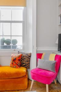 - un salon avec un canapé et une chaise dans l'établissement Vogue 1 bedroom Pimlico flat near Victoria Station, à Londres