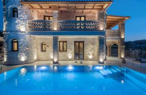 a villa with a swimming pool at night at Porta del mar Beach Resort in Méson Yerakaríon