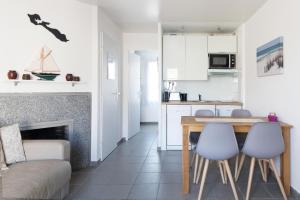 a kitchen and living room with a table and chairs at Appartement Valène in La Flotte