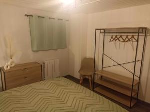 a bedroom with a bed and a chair and a dresser at A Bigeo in Saint-Sauveur-Marville