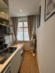 una pequeña cocina con fregadero y ventana en maison belle rade : l'amarre, en Dunkerque