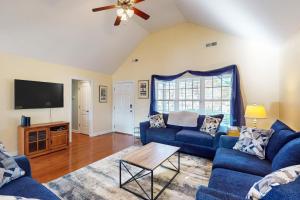 a living room with blue couches and a flat screen tv at The Lake Keziah House in Southport