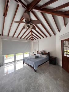 - une chambre avec un lit et un ventilateur de plafond dans l'établissement Finca Vista Primorosa, à Pereira