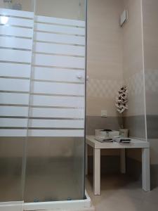 a glass shower in a room with a table at City Apartment in Gotse Delchev