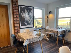a dining room with two tables and chairs at The Bridge B&B in Kilmaluag