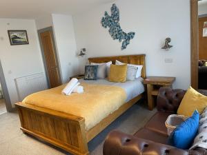 ein Schlafzimmer mit einem Bett und einem Sofa in der Unterkunft The Bridge B&B in Kilmaluag